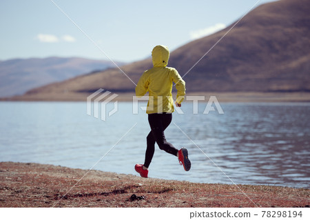 Woman trail runner cross country running  in winter lakeside 78298194