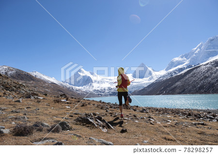 Woman trail runner cross country running in high altitude winter nature. 78298257