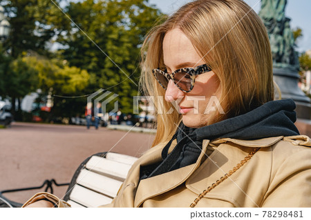 beautiful girl sitting on a bench in sunglasses beautiful girl sitting on a bench in sunglasses 78298481