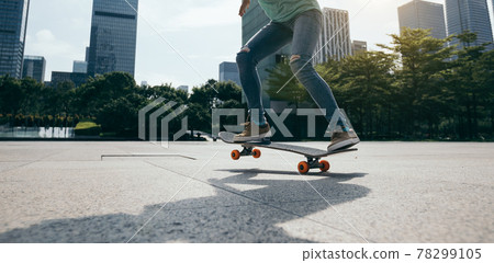 Asian woman skateboarder skateboarding in modern city 78299105