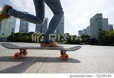 Asian woman skateboarder skateboarding in modern city 78299106