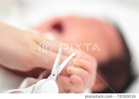 Mom cutting the nails of a newborn baby's hand Mom cutting the nails of a newborn baby's hand 78300016
