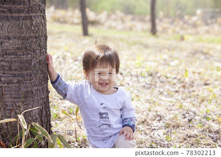 Baby playing in the cherry blossom park Baby playing in the cherry blossom park 78302213