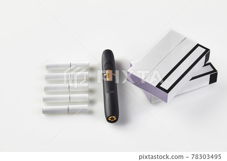 New generation black electronic cigarette, two packs with purple sides and five heatsticks isolated on white. Hi-tech heating tobacco system. Close up New generation black electronic cigarette, two packs with purple sides and five heatsticks isolated on white. Hi-tech heating tobacco system. Close up 78303495