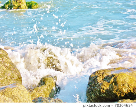 Splashing waves on rocks in the blue sea Splashing waves on rocks in the blue sea 78304654