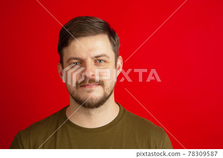 Portrait of young Caucasian man isolated on bright red studio background. Concept of facial expressions, human emotions. Portrait of young Caucasian man isolated on bright red studio background. Concept of facial expressions, human emotions. 78309587