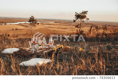 Wooden table with glassware arranged for picnic 78309813