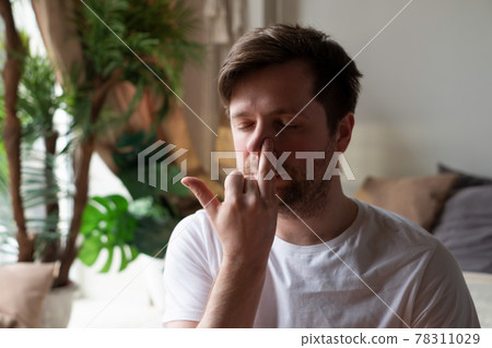 Caucasian mature man practicing yoga sitting, making Alternate Nostril Breathing 78311029