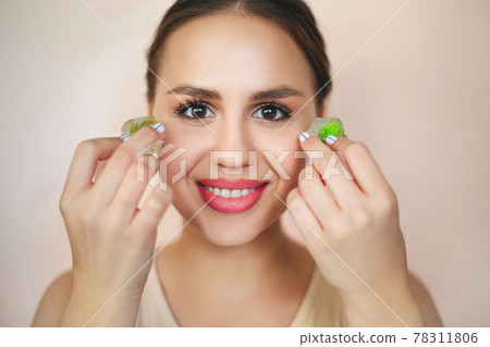 Portrait of the woman with ice cubes for skincare routine Portrait of the woman with ice cubes for skincare routine 78311806