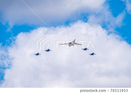 Moscow, Russia - May, 05, 2021: The Tu-160 strategic missile carrier, accompanied by four Su-35S fighter jets, flies over Red Square during the preparation of the May 9 parade. Moscow, Russia - May, 05, 2021: The Tu-160 strategic missile carrier, accompanied by four Su-35S fighter jets, flies over Red Square during the preparation of the May 9 parade. 78311933