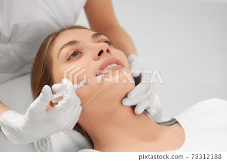 Young woman on procedure lip augmentation. Young woman on procedure lip augmentation. 78312188