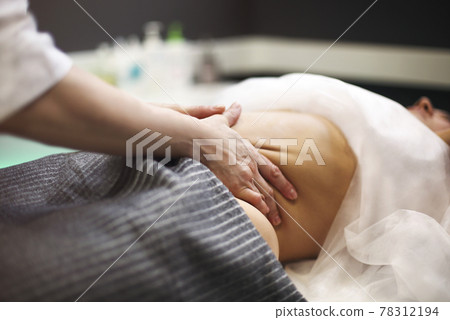 Young woman having stomach massage 78312194