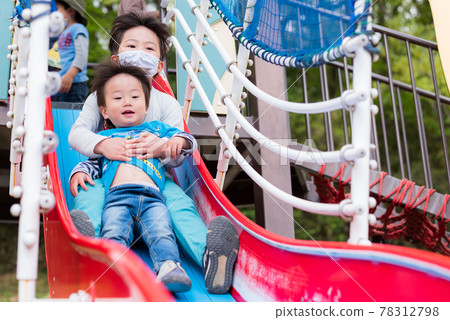 孩子們在公園的滑梯上玩耍 孩子們在公園的滑梯上玩耍 78312798