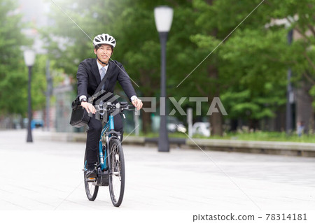 一個穿西裝騎自行車的年輕人 78314181