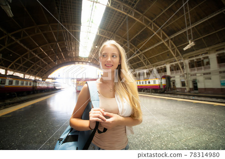 young woman waiting in vintage train, relaxed and carefree at the station platform in Bangkok, Thailand before catching a train. Travel photography. Lifestyle. 78314980