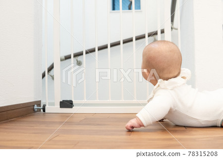 Baby in front of the baby gate 78315208