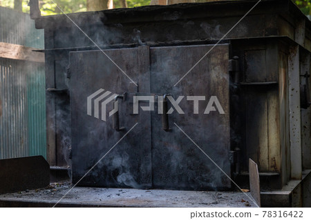 A photo of burning garbage in an outdoor incinerator. Dioxin generation. Image of environmental problems. A photo of burning garbage in an outdoor incinerator. Dioxin generation. Image of environmental problems. 78316422