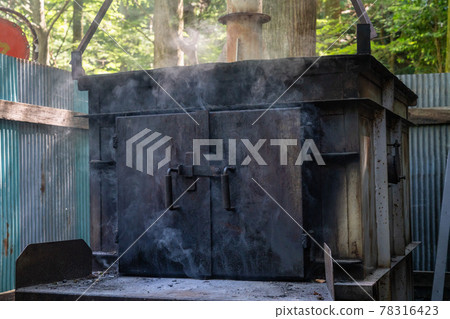 A photo of burning garbage in an outdoor incinerator. Dioxin generation. Image of environmental problems. 78316423