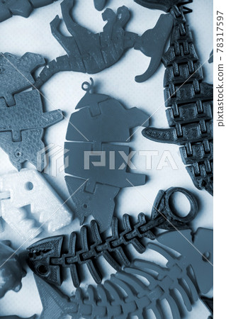Many bright multi-colored objects printed on 3d printer lie on flat surface Many bright multi-colored objects printed on 3d printer lie on flat surface 78317597