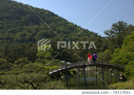 一對夫婦在日本花園的橋上打著傘看風景 一對夫婦在日本花園的橋上打著傘看風景 78317691
