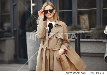 Stylish woman in a spring city with shopping bags Stylish woman in a spring city with shopping bags 78319331