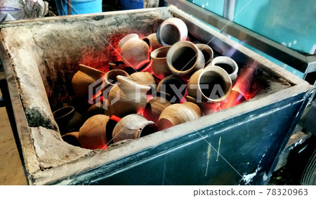 Heating clay pots in coal to make tea Heating clay pots in coal to make tea 78320963