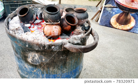 Heating clay pots in coal to make tea 78320971