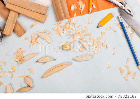 Handmade wooden fishing tacles graph paper background with tools and blanks. 78322162
