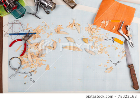 Handmade wooden fishing tacles graph paper background with tools and blanks. 78322168