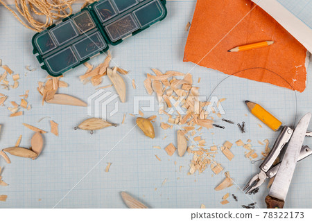 Handmade wooden fishing tacles graph paper background with tools and blanks. 78322173
