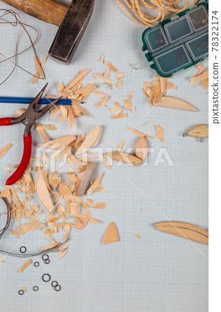 Handmade wooden fishing tacles graph paper background with tools and blanks. 78322174