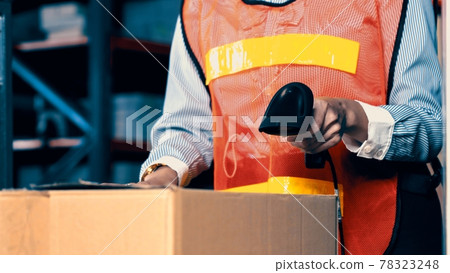Warehouse worker using barcode scanner in storehouse Warehouse worker using barcode scanner in storehouse 78323248