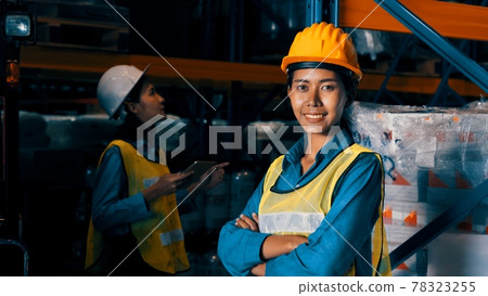 Portrait of young woman warehouse worker smiling in the storehouse Portrait of young woman warehouse worker smiling in the storehouse 78323255