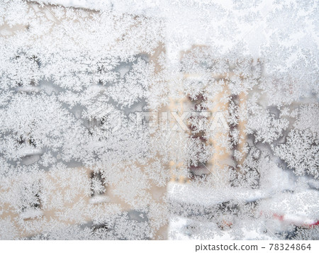 frosted window glass and view of houses in city 78324864