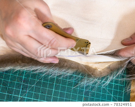 furrier cuts the edge of fur pelt by knife furrier cuts the edge of fur pelt by knife 78324951
