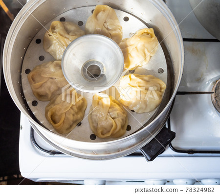above view homemade manti are cooking in steamer 78324982