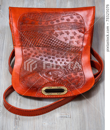 back side of open orange embossed leather handbag 78325076