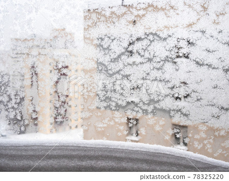 snowdrift on window frame and frosty glass in city snowdrift on window frame and frosty glass in city 78325220