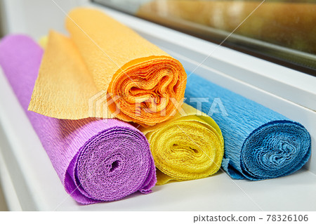 Four rolls multicolored Crepe Paper for creation lie on sill. 78326106