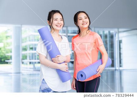 Young woman with yoga mat in the gym 78329444