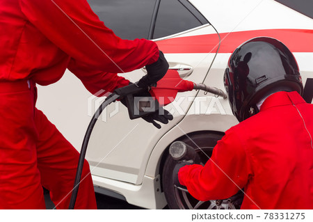 Auto mechanic changing car wheel and fill fuel 78331275