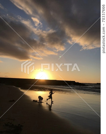 Children playing on the sandy beach in the evening 78337666
