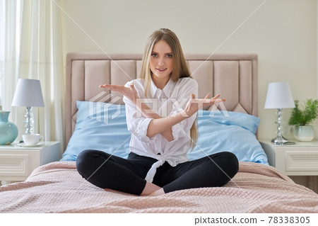 Serious anxious worried young woman sitting at home in bed 78338305