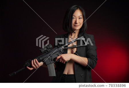 asian woman in a jacket with an automatic rifle in her hands mafia fighter 78338896