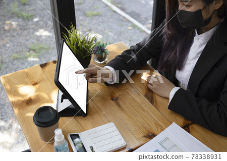 Cropped shot businesswoman in face mask using digital tablet in office. Cropped shot businesswoman in face mask using digital tablet in office. 78338931