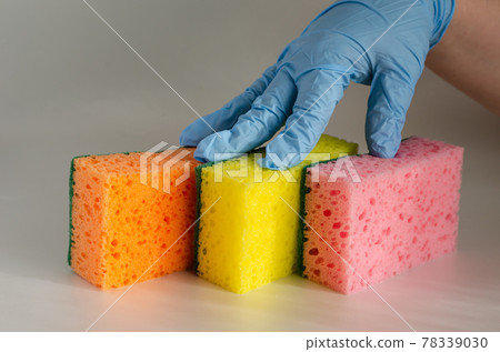Three multi-colored kitchen sponges on the table. 78339030