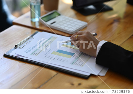 Close up view accountant analyzing financial data on wooden table. Close up view accountant analyzing financial data on wooden table. 78339376