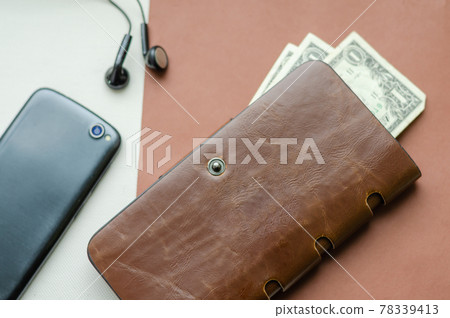 Wallet, phone and headphones on the table. 78339413