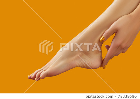 Female leg and hand with summer nail design on orange background Female leg and hand with summer nail design on orange background 78339580