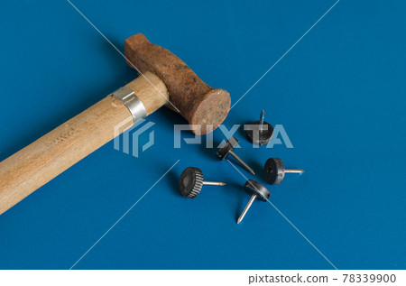 Old hammer and furniture nails on a blue background. Old hammer and furniture nails on a blue background. 78339900